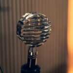 Close-up of a vintage microphone with a striped background in a studio environment.