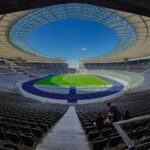A wide-angle shot of the iconic Berlin Olympic Stadium showcasing its grandeur and modern architecture.