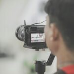 Close-up of a photographer capturing an event indoors with a professional camera setup.