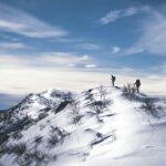 two person hiking on mountain with snow