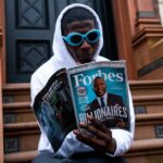 man in white long sleeve shirt holding magazine