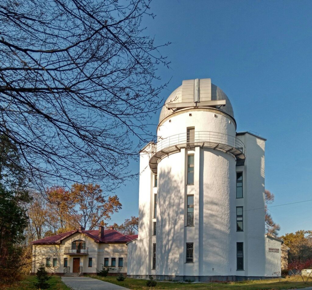 A large white building sitting next to a tree