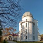 A large white building sitting next to a tree